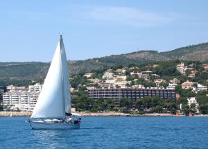 a sailboat in the water in front of a city at Hotel de Mar Gran Meliá - Adults Only - The Leading Hotels of the World in Illetas