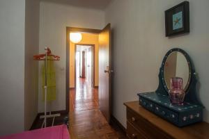 a room with a mirror and a dresser with a vase at Casa Caió in Ribeira Grande