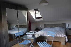 een slaapkamer met een bed en twee blauwe stoelen bij Chambre en Ardenne in Graide