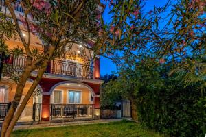 
a house with a tree in front of it at Tsiolis Studios & Apartments in Tsilivi
