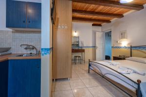 una cucina e una camera con letto e lavandino di Tsiolis Studios & Apartments a Tsilivi