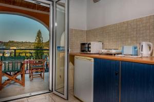 una cucina con bancone e un balcone con tavolo di Tsiolis Studios & Apartments a Tsilivi