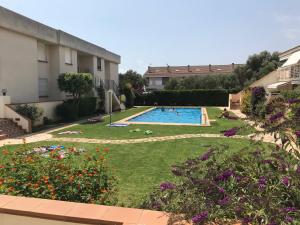 a backyard with a swimming pool and flowers at APARTAMENTO Nº 13 URB. CALA JOSEP in Vinarós