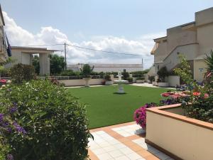 a garden with a lawn and flowers in a building at APARTAMENTO Nº 13 URB. CALA JOSEP in Vinarós