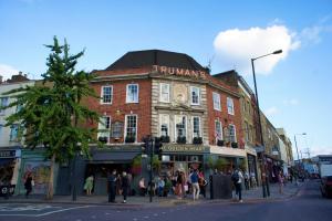 un grupo de personas cruzando una calle frente a un edificio en Brick Lane Spitalfields Apartment, en Londres