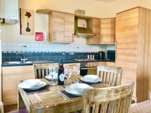 a kitchen with a wooden table with chairs and wine glasses at Carr View Hall Apt3 Grade II Listed in Sleights