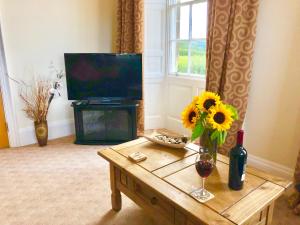 a living room with a vase of sunflowers on a coffee table at Carr View Hall Apt3 Grade II Listed in Sleights