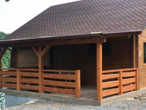 une grande cabane en bois avec un toit brun dans l'établissement Rancho 555, à Oujhorod