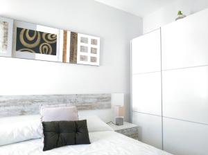 サラマンカにあるCielo de Salamancaの白い壁のベッドルーム1室、ベッド1台(白いシーツ付)