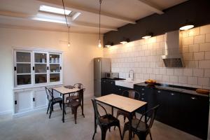 una cocina con 2 mesas y sillas. en Akassa Alojamientos Bioclimaticos en las Hurdes, en Pinofranqueado