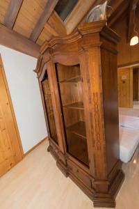 a large wooden cabinet in a room with a ceiling at BnB Alpenblick in Lütisburg