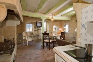 una cucina e una sala da pranzo con tavolo e sedie di Logis Demeure de la Vignole a Turquant