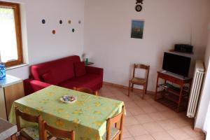 a living room with a table and a red couch at Casa al Lago Trentuno B in Zenna