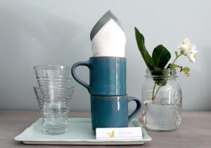 a blue coffee cup sitting on a table next to a glass at il gabbiano giallo in Fano