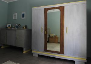 a room with a door with a mirror and a dresser at il gabbiano giallo in Fano