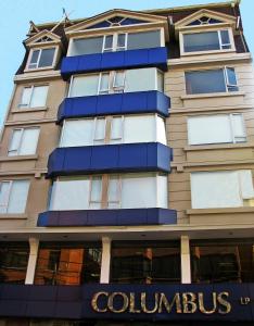 
a blue and white building with a large window at Hotel LP Columbus in La Paz

