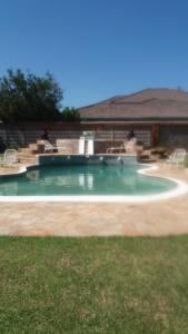 a swimming pool with a fountain in a yard at Tshulu Tsha Nabe B&B in Bulawayo