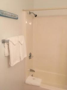 a bathroom with a shower with white towels at Ocean Cove Motel in Virginia Beach