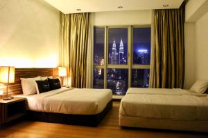 a hotel room with two beds and a window at T1 KLCC view Studio@Regalia Infinity Pool in Kuala Lumpur