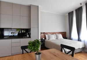 a bedroom with a bed and a table and a kitchen at Karlo Main Square Apartments in Zagreb