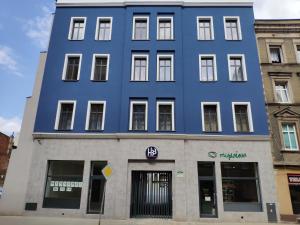 a blue building on the corner of a street at H33 Apartamenty in Bytom