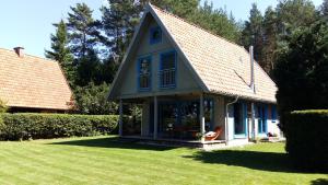 uma casa com um telhado azul e um relvado em Blue Bird em Pluski