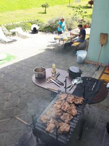 een grill met vlees erop met mensen aan tafel bij Apartment Comeback in Zagreb