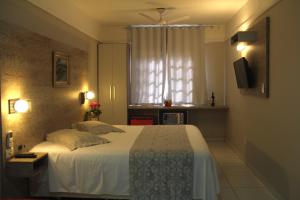 una camera con un grande letto e una finestra di Chalés Saint Germain a Florianópolis