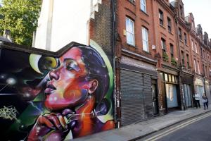 una pintura de un hombre en una pared en una calle en Brick Lane Studios, en Londres 17 fotos más