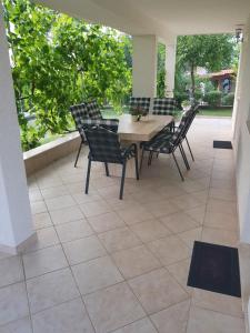 a table and chairs sitting on a patio at Apartmani Jureta in Okrug Gornji