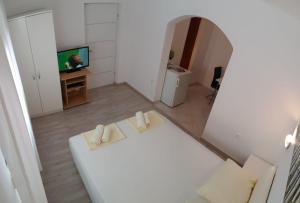 a living room with a white couch and a television at Apartmani Jureta in Okrug Gornji