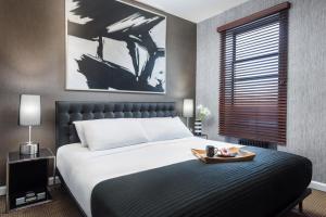 a bedroom with a bed and a painting on the wall at Park West Hotel in New York