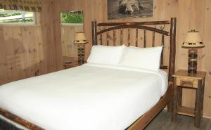 a bedroom with a large bed with a wooden headboard at Belknap Point Inn in Gilford