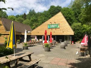 un ristorante con tavoli e ombrelloni di fronte di Durbuy-Bungalow a Durbuy