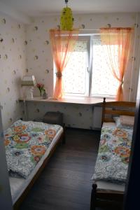 een slaapkamer met 2 bedden en een raam met gordijnen bij Butterfly Apartment in Visaginas