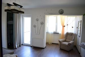 sala de estar con silla y ventana en Butterfly Apartment, en Visaginas