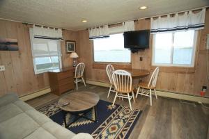 a living room with a couch and a table and chairs at Belknap Point Inn in Gilford