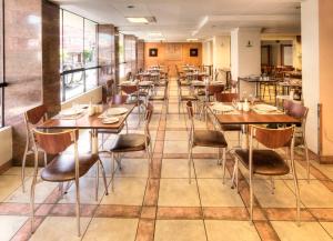 a row of tables and chairs in a restaurant at Hotel LP Columbus in La Paz