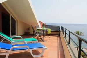 a balcony with chairs and a table and the ocean at Penthouse Marina Sol in Madalena do Mar