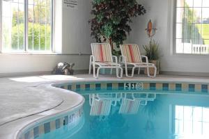 two chairs and a swimming pool in a house at Essenhaus Inn & Conf. Center in Middlebury