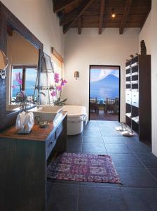 een grote badkamer met een bad en een wastafel bij Hotel Casa Palopo in Santa Catarina Palopó