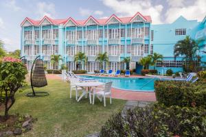 a resort with a pool and tables and chairs at Bay Gardens Marina Haven in Gros Islet