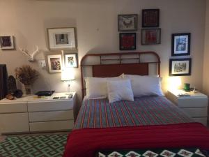 um quarto com uma cama e algumas fotografias na parede em The Wild Rose em Miami