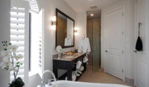 ein Badezimmer mit einem Waschbecken, einer Badewanne und einem Spiegel in der Unterkunft The Hotel Zamora in St Pete Beach