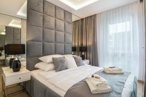 a bedroom with a large bed with towels on it at Crystal Luxury Apartments Rakowicka 22H in Kraków