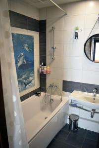 ein Badezimmer mit einer Badewanne und einem Waschbecken in der Unterkunft Butterfly Apartment in Visaginas