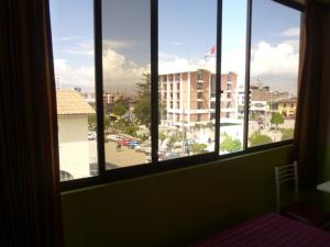 Zimmer mit Fenster und Blick auf ein Gebäude in der Unterkunft Hospedaje Centro in Huancayo