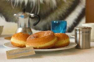 three donuts on a plate on a table at Residence San Miguel (centro storico) in Vicenza