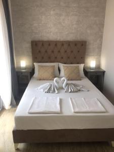 a large white bed with two white towels on it at Soheds in Budva