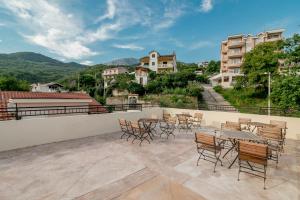 a patio with chairs and tables on a balcony at SunnyApartments in Herceg-Novi
